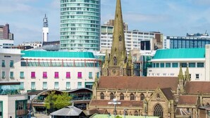 A cityscape with a mix of modern and historical architecture, including a prominent church tower and a modern glass building. - Birmingham Central Backpackers - Hostel (Birmingham)