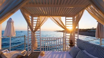 Aan een privéstrand, ligstoelen, parasols, strandlakens