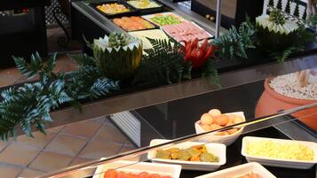 Een buffet met diverse gerechten en decoratieve planten.