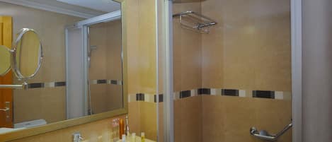 A bathroom with a sink, mirror, and shower.