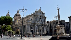 A historic building with classical architecture, including columns and statues, and a prominent fountain in the foreground. - B&B Gisira (Catania)