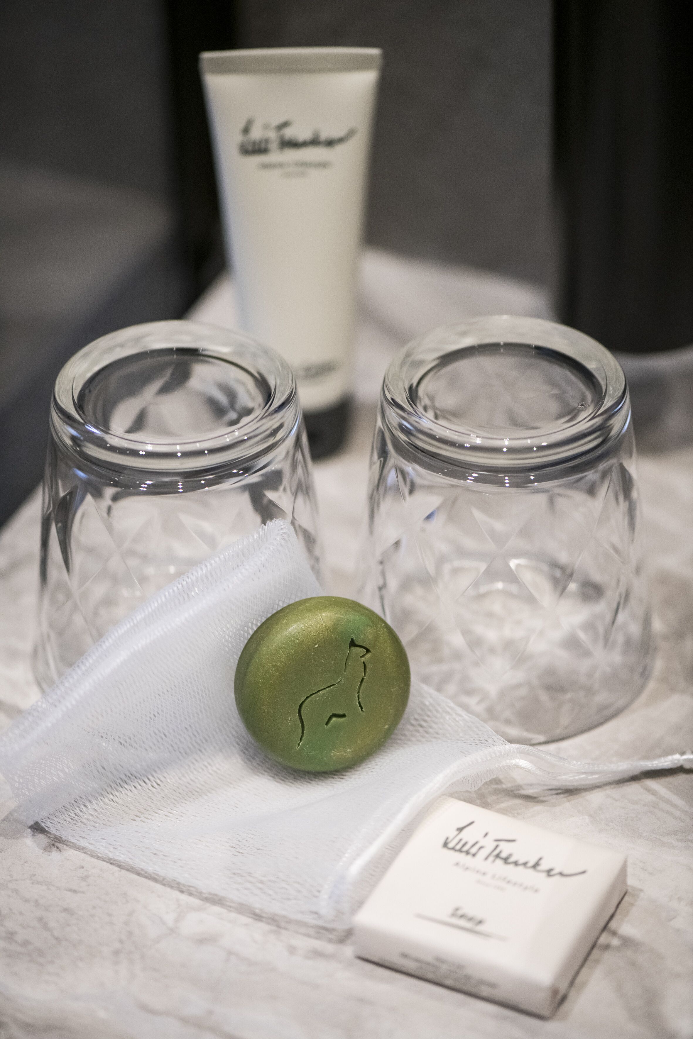 Two glass jars with a green object and a white box labeled "Lili's Trinker" on a marble surface.