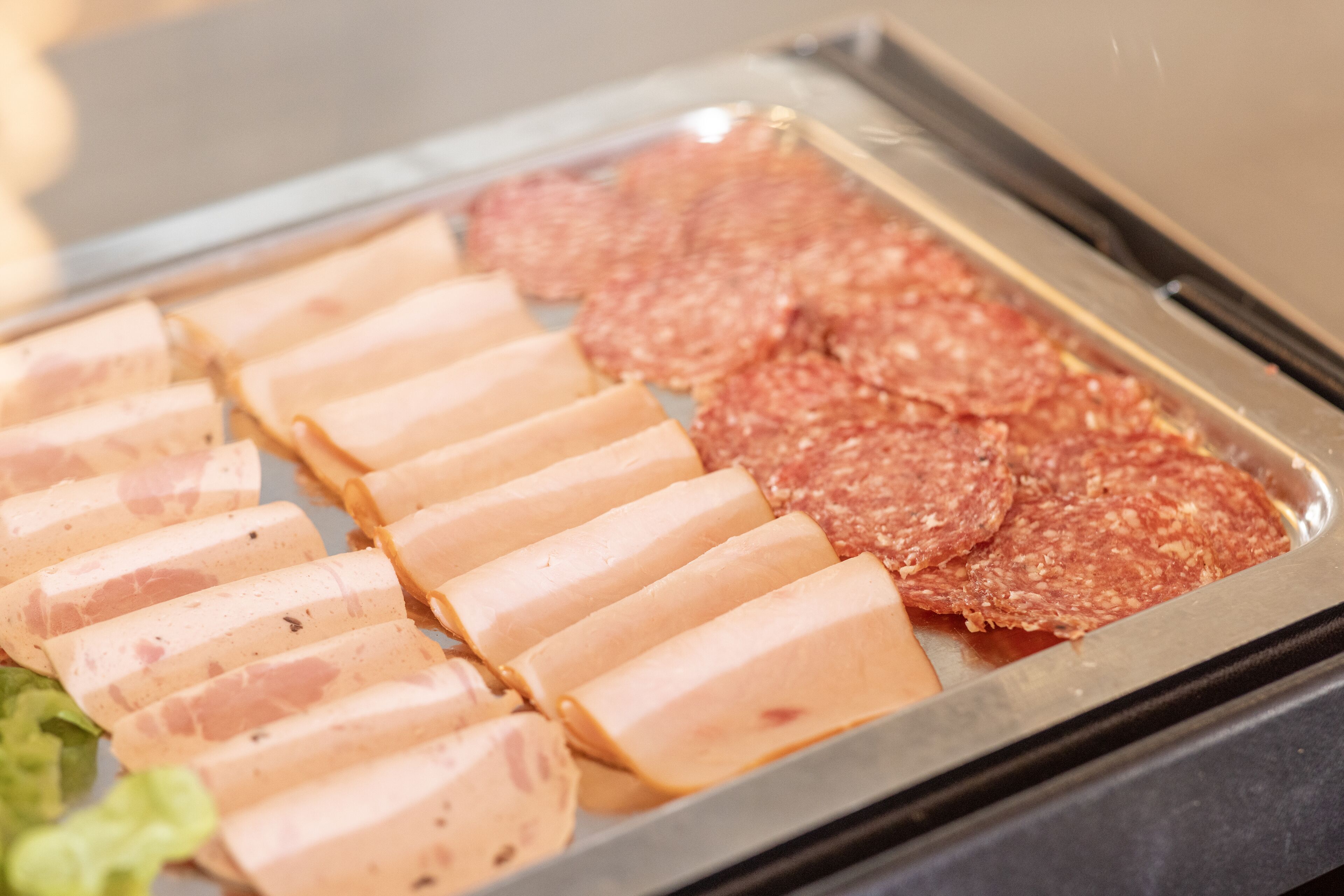 A buffet with sliced meats and vegetables.