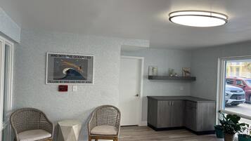 A modern kitchen with grey cabinets, a built-in shelf, and a poster on the wall.