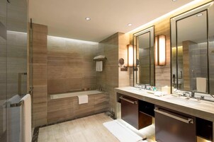 Un baño moderno con cabina de ducha de vidrio, una bañera independiente y un tocador con un espejo grande.