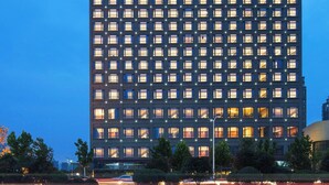 Un edificio de gran altura con ventanas iluminadas y un letrero que dice "FOUR POINTS BY GENERATION".
