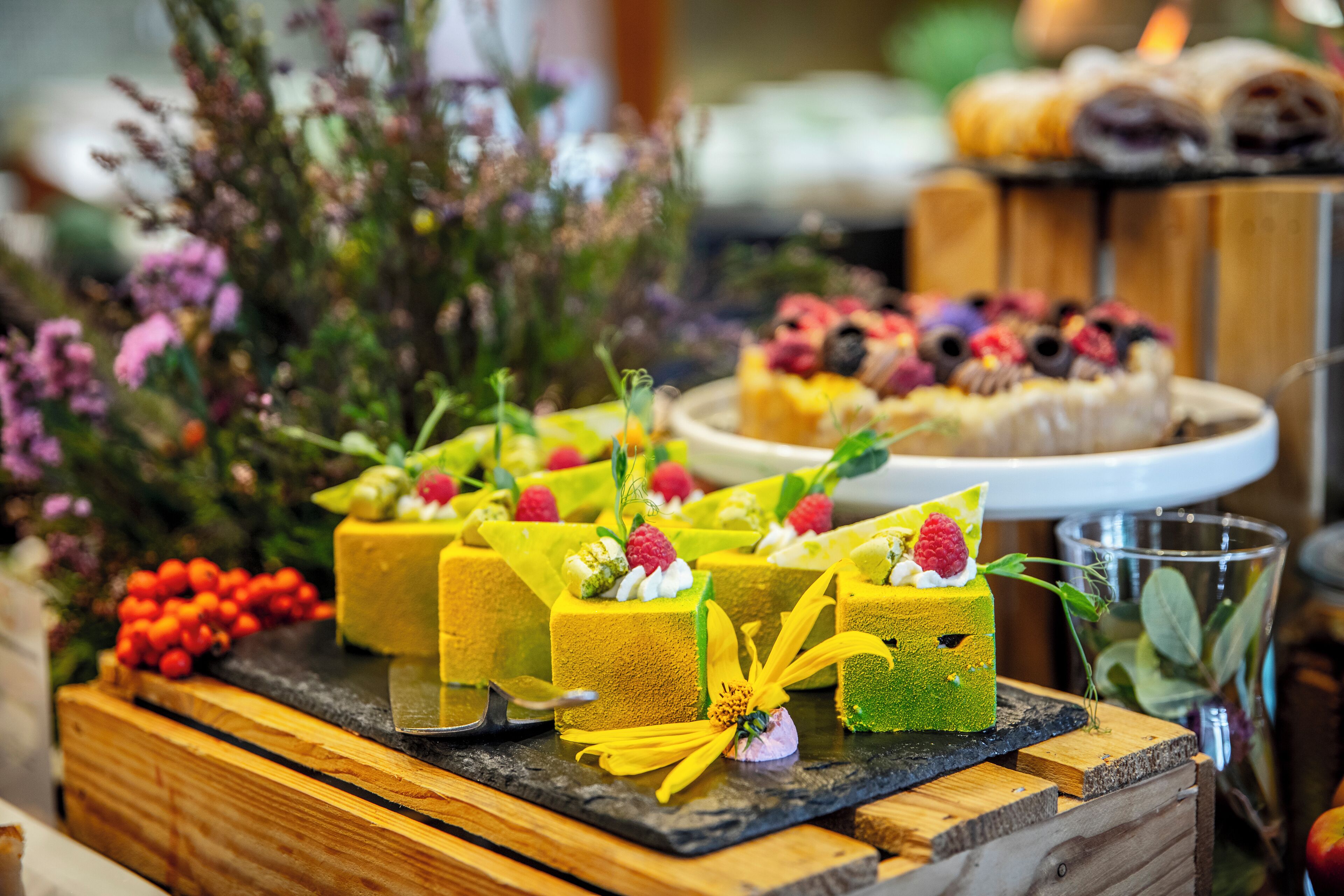 A dessert display with various cakes and fruits.