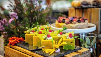 A dessert display with various cakes and fruits.