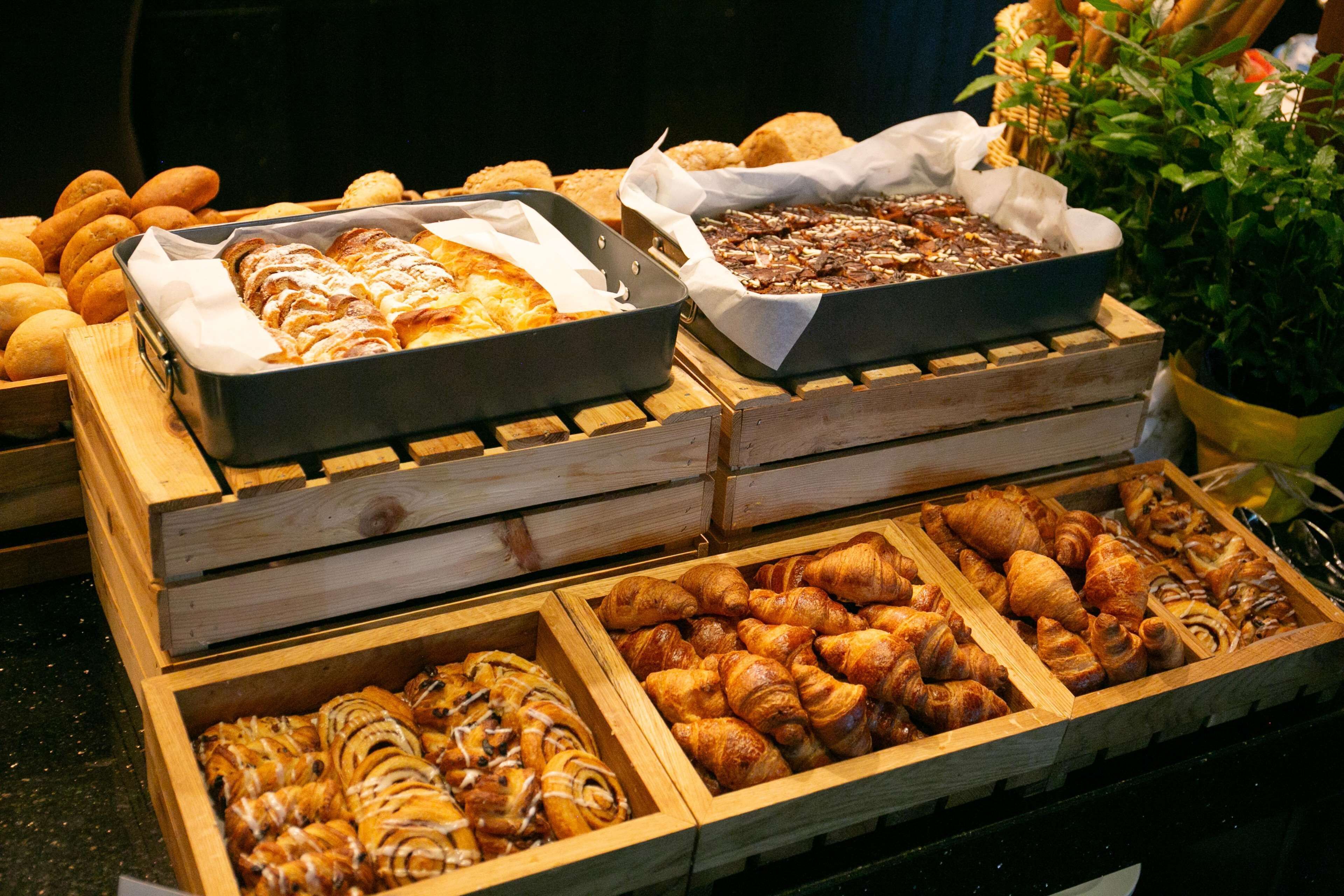 Une vitrine de boulangerie présentant diverses pâtisseries dans des caisses en bois.