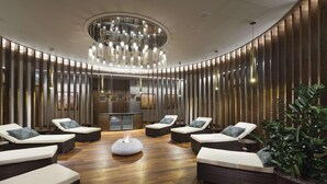 A modern lounge area with wicker lounge chairs, a central white ottoman, and a stylish ceiling light fixture. - DoubleTree By Hilton Hotel & Conference Centre Warsaw (Warsaw)