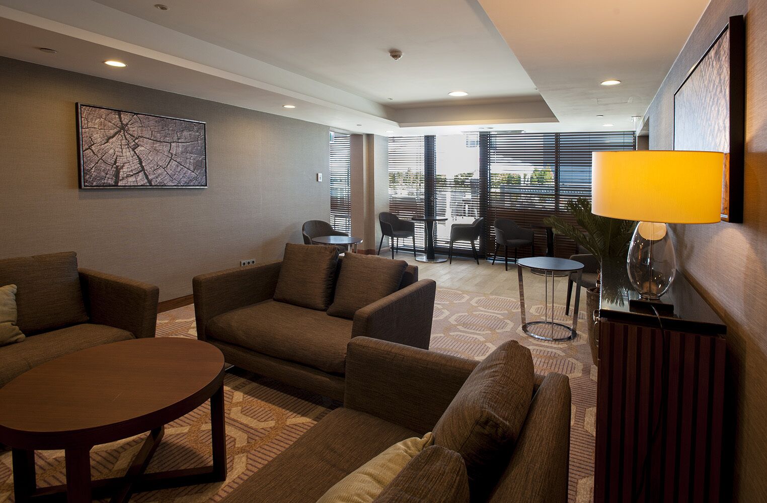 Une chambre d’hôtel moderne, équipée d’un canapé, d’une petite table et d’une lampe.