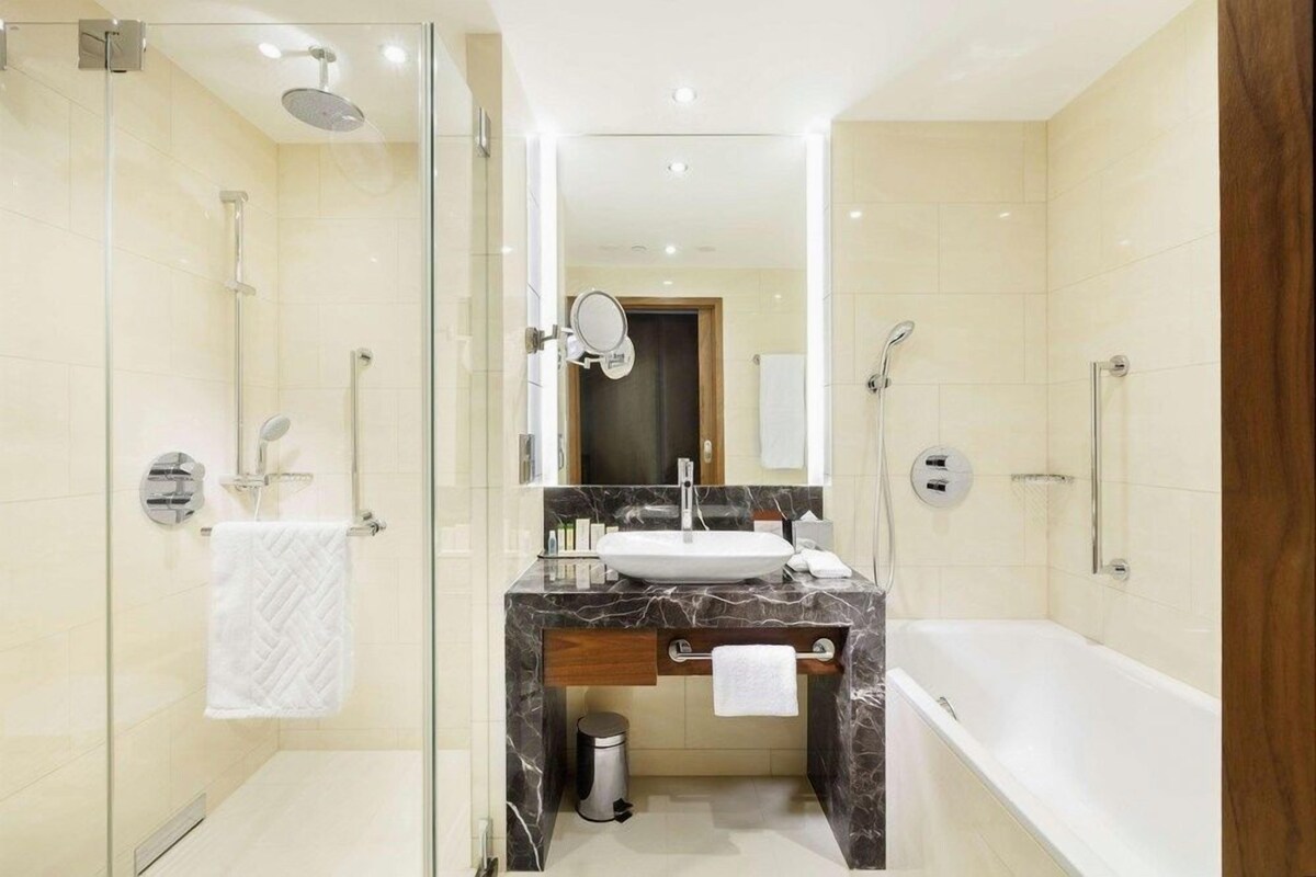 Bathroom | Deep soaking tub, designer toiletries, hair dryer, slippers
