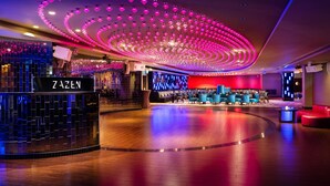 A modern hotel lobby with a curved seating area, a reception desk labeled "ZAZEN," and a ceiling with circular light fixtures. - DoubleTree By Hilton Hotel & Conference Centre Warsaw (Warsaw)