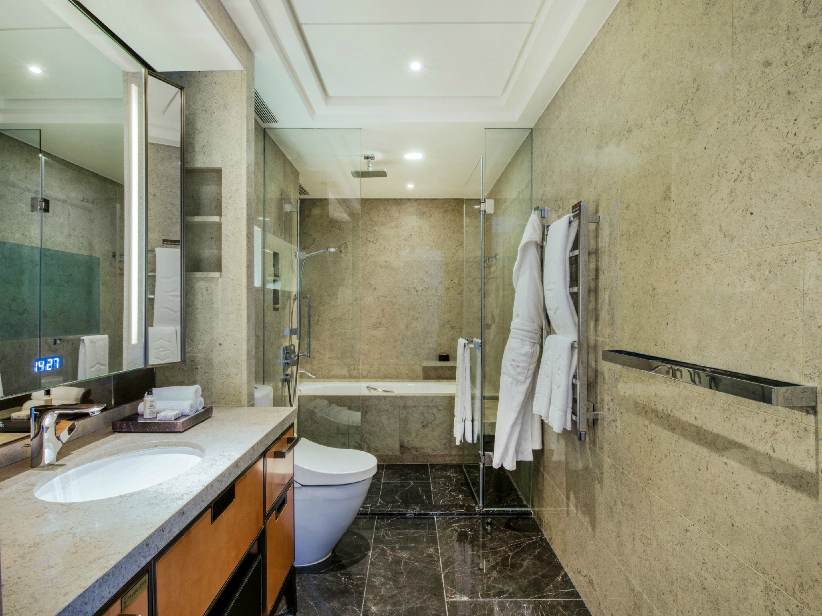 A modern bathroom with a glass-enclosed shower, a bathtub, and a vanity with a sink and mirror.