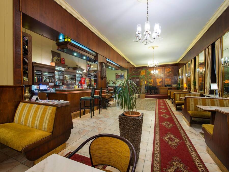 Een hotel lobby met houten meubilair, een bar en een kroonluchter.