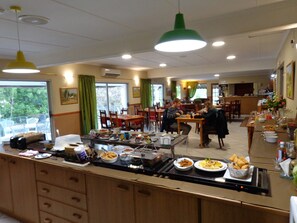 Un restaurant proposant un buffet, avec plusieurs tables et chaises pour les clients.