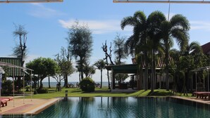 Una piscina al aire libre, sombrillas, tumbonas