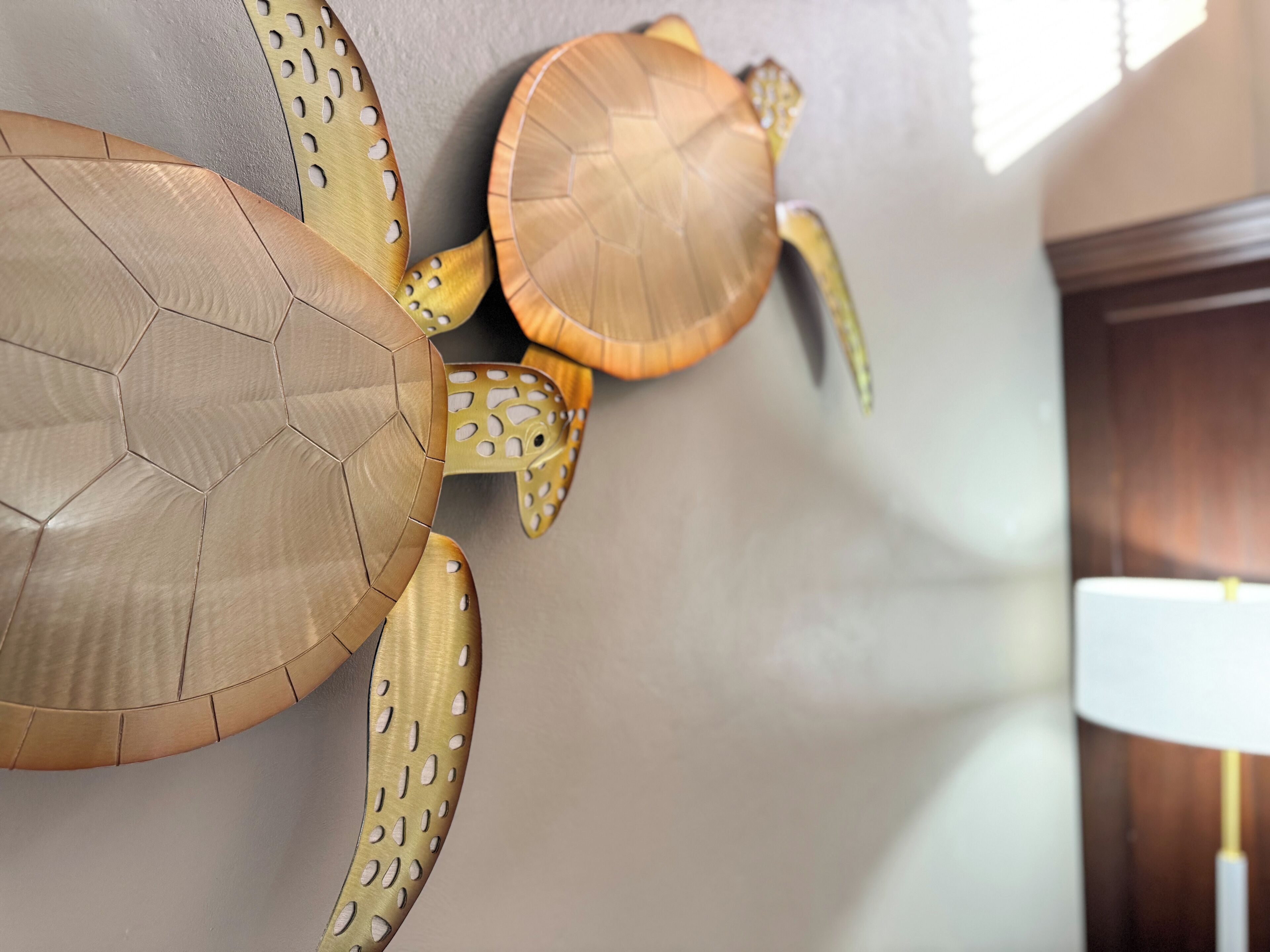 A wall with three large, textured wall art pieces resembling sea creatures.