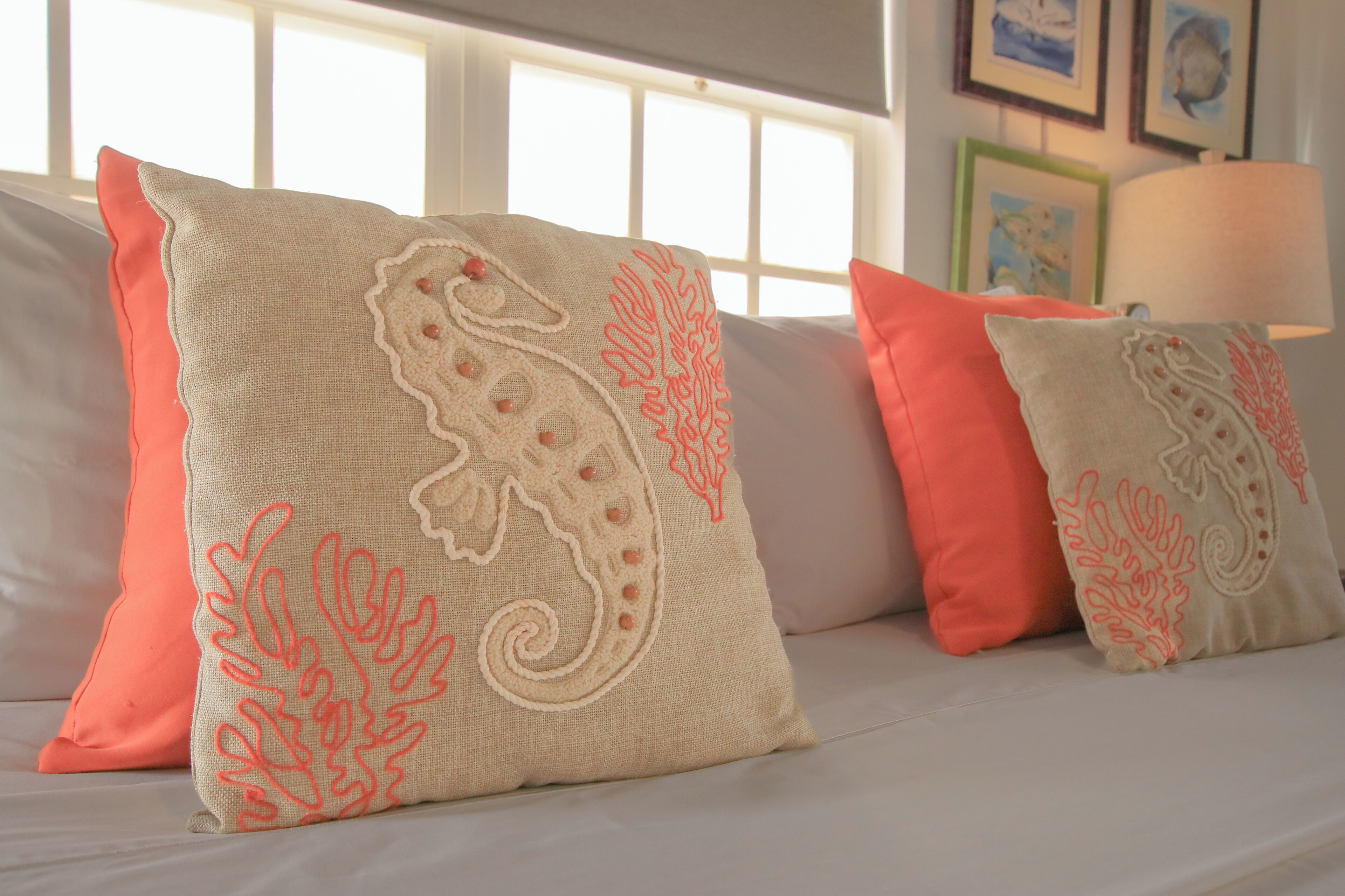 Un sofá con cojines decorativos con motivos de caballitos de mar.