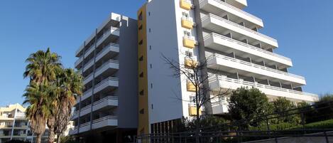 A multi-story hotel with balconies and a clear sky.