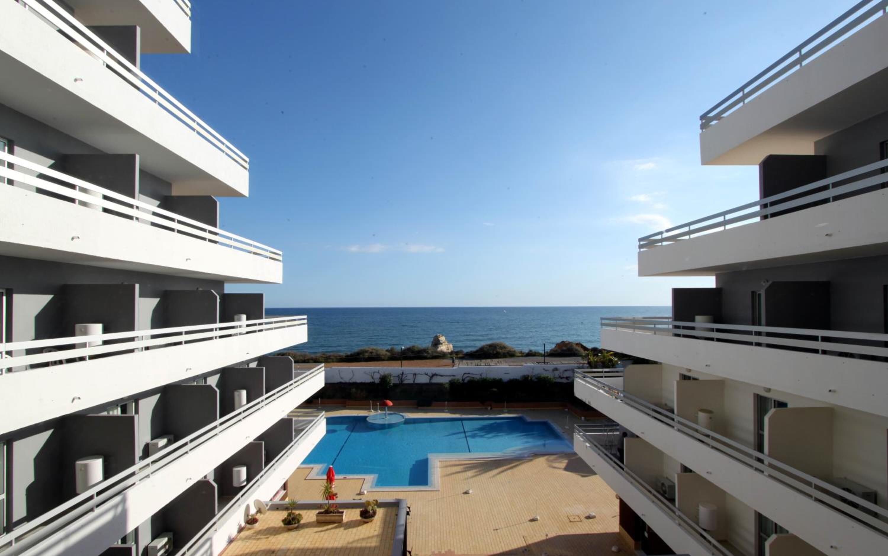 A modern hotel with a pool and ocean view.