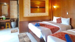 A hotel room with two beds, a large painting, a wooden ceiling, a desk with a chair, and an air conditioning unit. - Blue Andaman Lanta Resort (Ko Lanta)
