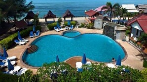 A resort with a large swimming pool, lounge chairs, and a view of the ocean. - Blue Andaman Lanta Resort (Ko Lanta)