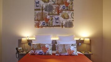 A hotel room with a bed, two bedside tables, a telephone, and a wall art piece.