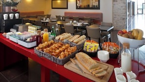 Un bufé de desayuno con diversas bollerías, pan y bebidas.