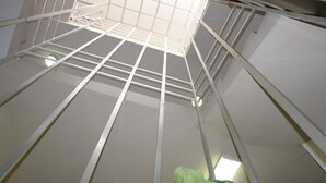 A room with a high ceiling, white beams, and a skylight. - Hotel Fiesta Versalles (Monterrey)