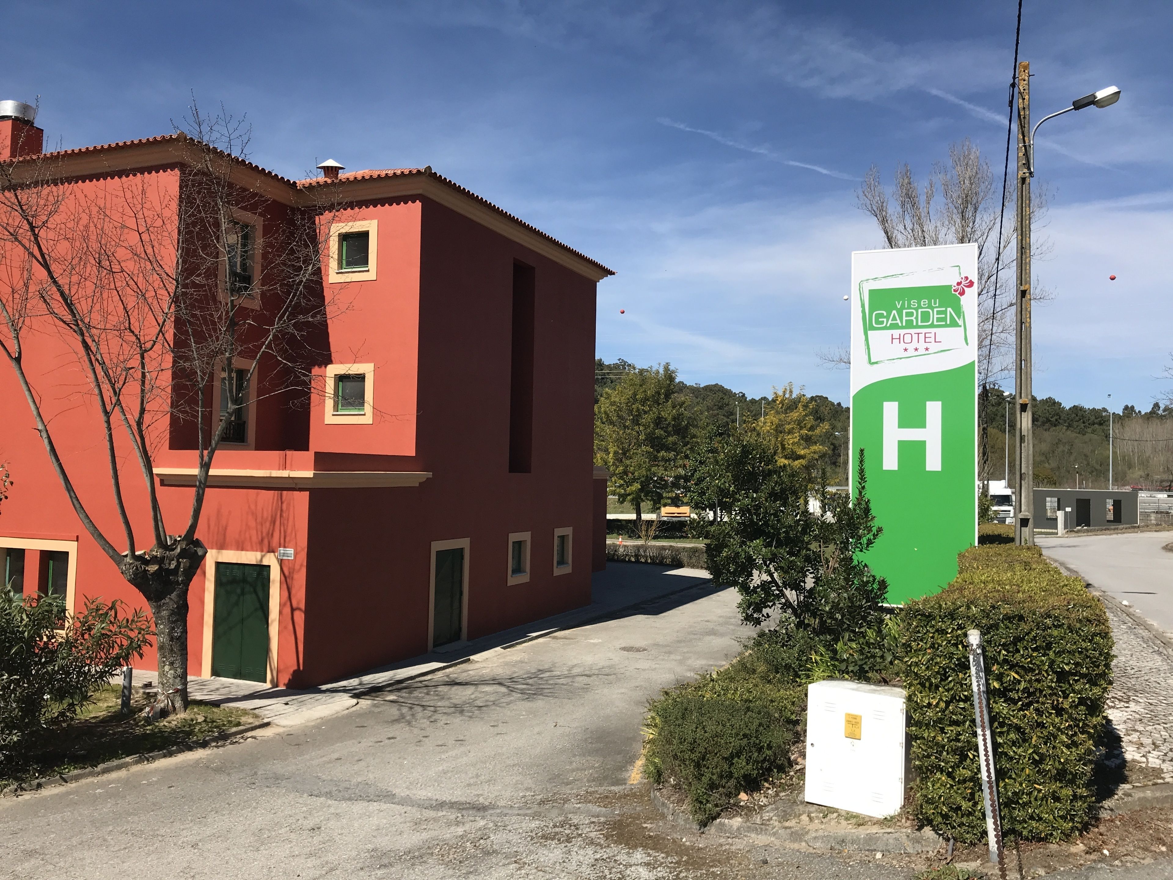 Ein rotes Gebäude mit einem Schild für das Viseu Garden Hotel.