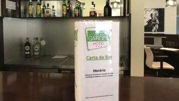 Un bar de hotel con un panel que muestra el horario de apertura.