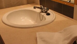 A bathroom sink with a faucet and a towel on the counter.