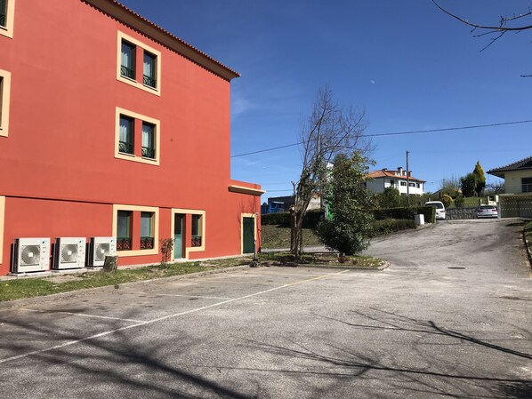 A red building with multiple windows and a gated driveway.