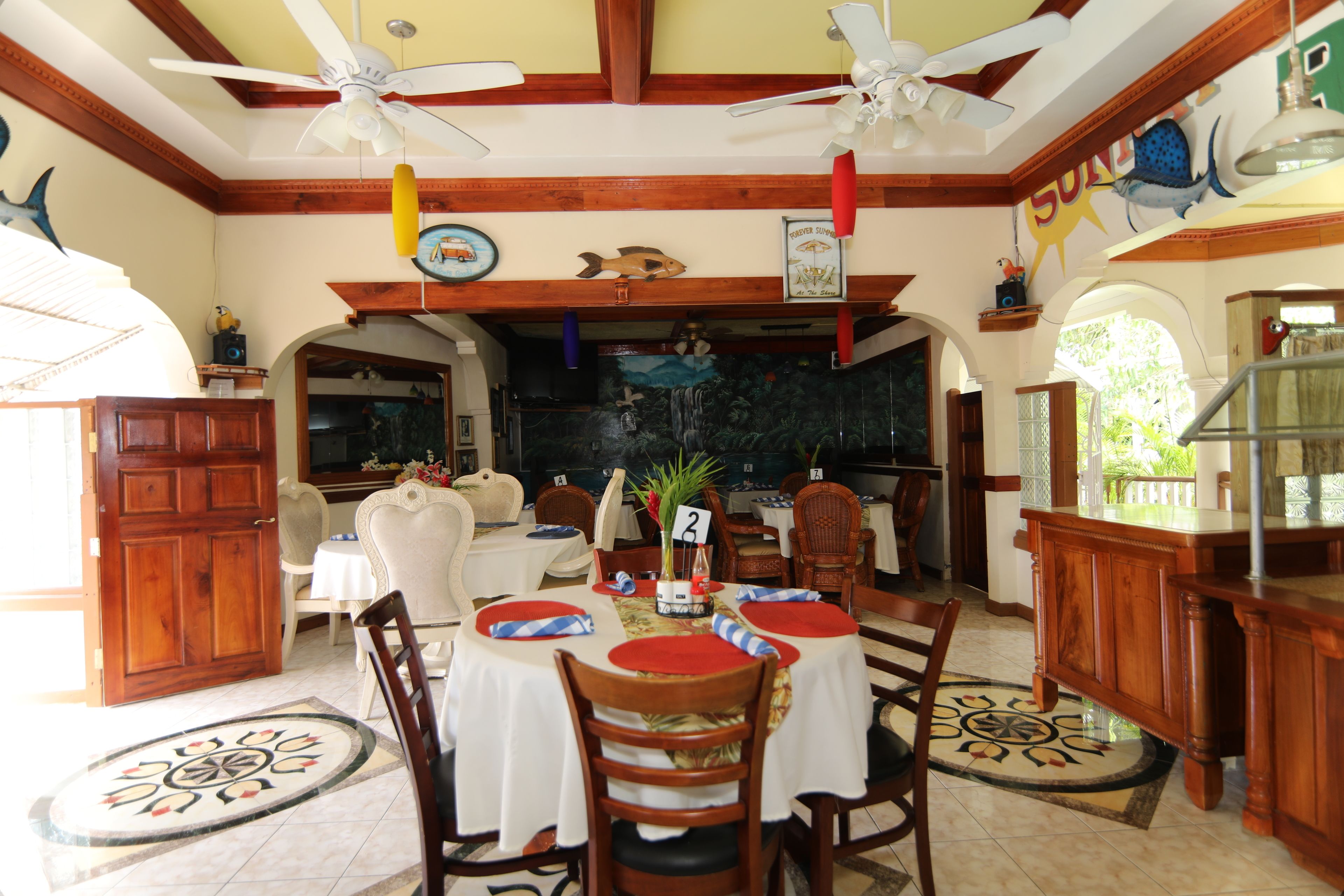 A dining area with a round table set for four, wooden chairs, and a ceiling fan.