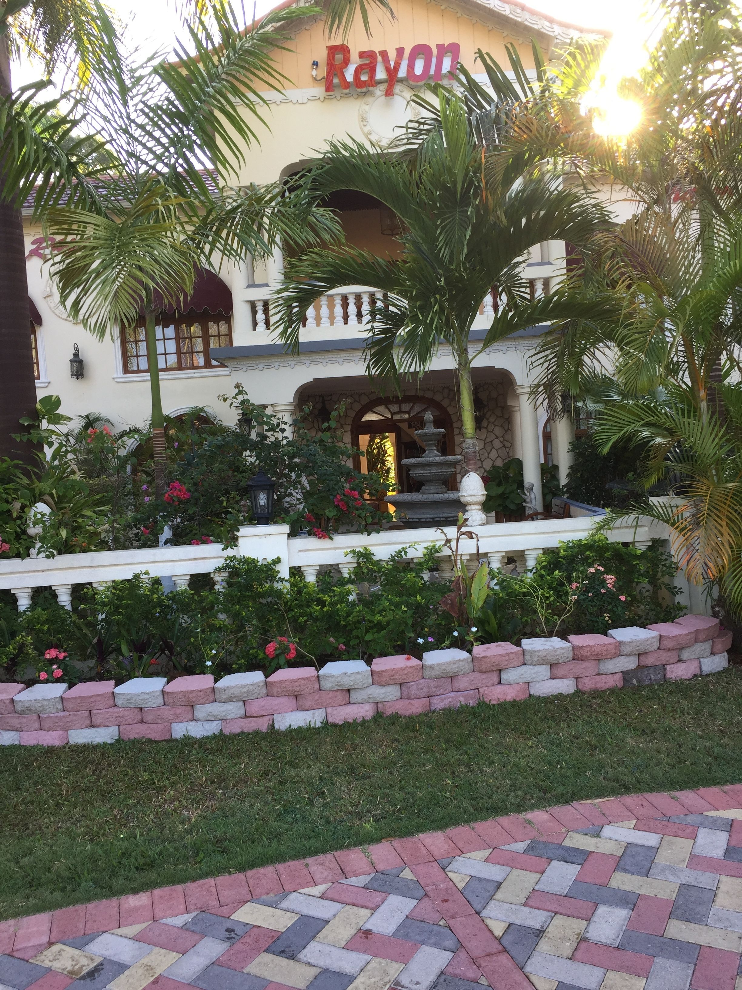 A hotel with a sign reading "Rayon" and a fountain in the front.