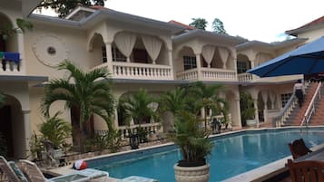 Una piscina al aire libre, sillones reclinables de piscina