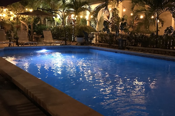 Una piscina al aire libre, sillones reclinables de piscina