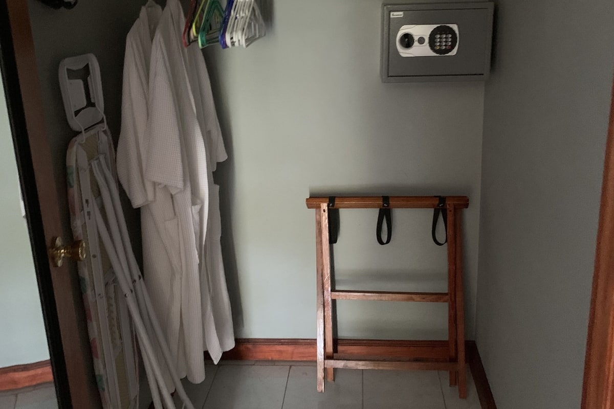 Un lavadero pequeño con un estante de madera, un tendedero y una secadora de pared.