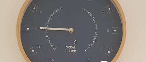 Un reloj de pared con marco de madera y esfera negra que muestra la hora.