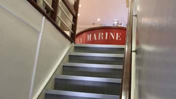 Una escalera con barandilla de madera y un letrero que dice "LA MARINE".