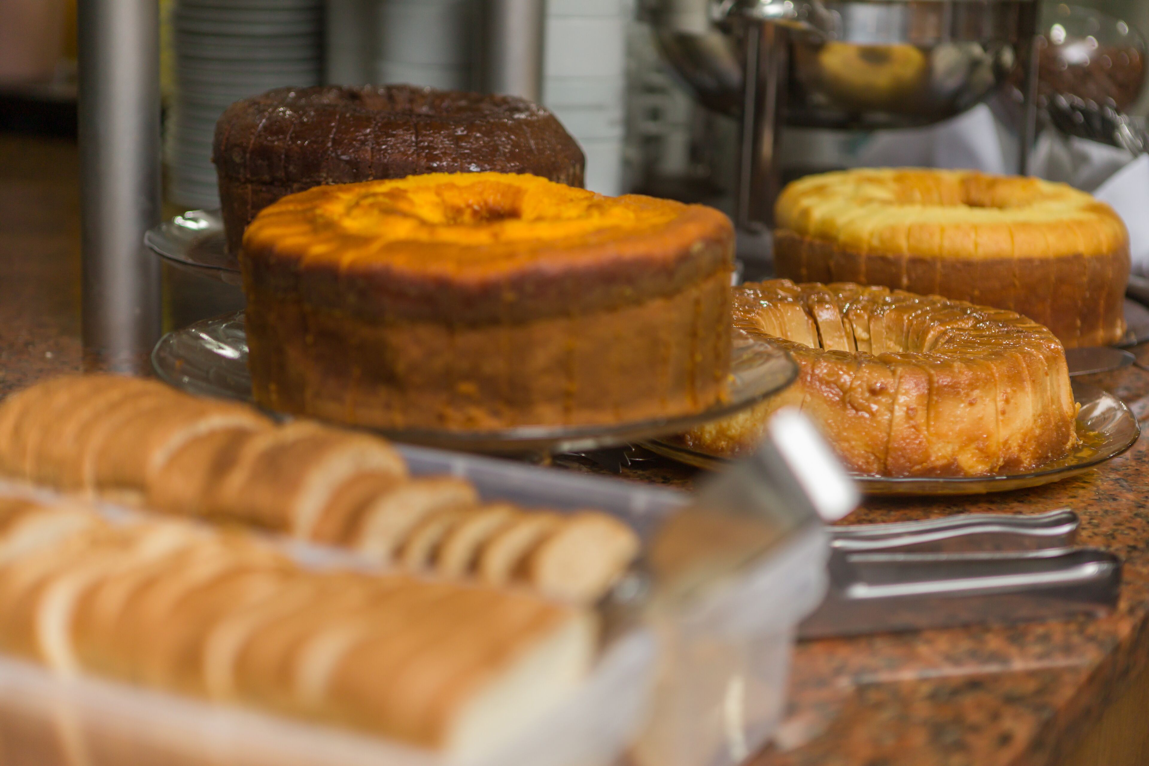 Une variété de produits de boulangerie présentés sur un présentoir en verre.