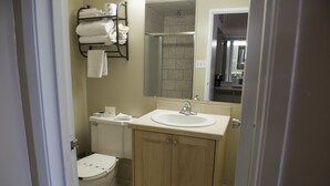 A bathroom with a toilet, sink, and shower. - Travel Inn (Laramie)