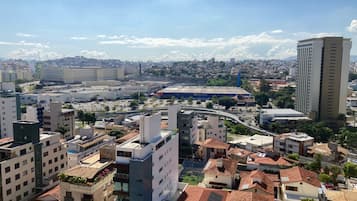 A cityscape with modern and traditional buildings, a prominent stadium, and a highway.
