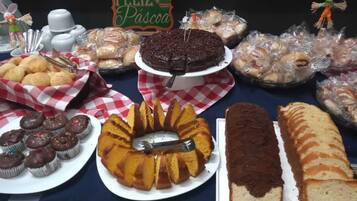 A table with various baked goods including a bundt cake, cupcakes, and bread.