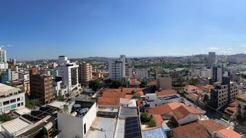 Paisagem urbana com diversos tipos de edifícios, incluindo arranha-céus e edifícios baixos, sob um céu claro.