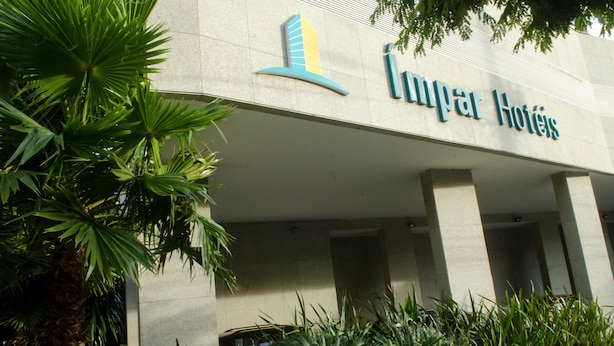 A hotel entrance with a modern design, featuring a prominent logo and the name 'Lumar Hotels'. - Ímpar Suítes Expominas (Belo Horizonte)