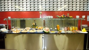 A buffet with various food items and a glass display case. - Ímpar Suítes Expominas (Belo Horizonte)