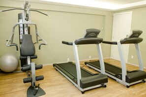 A gym with a stationary bike, elliptical, and two treadmills. - Ímpar Suítes Expominas (Belo Horizonte)