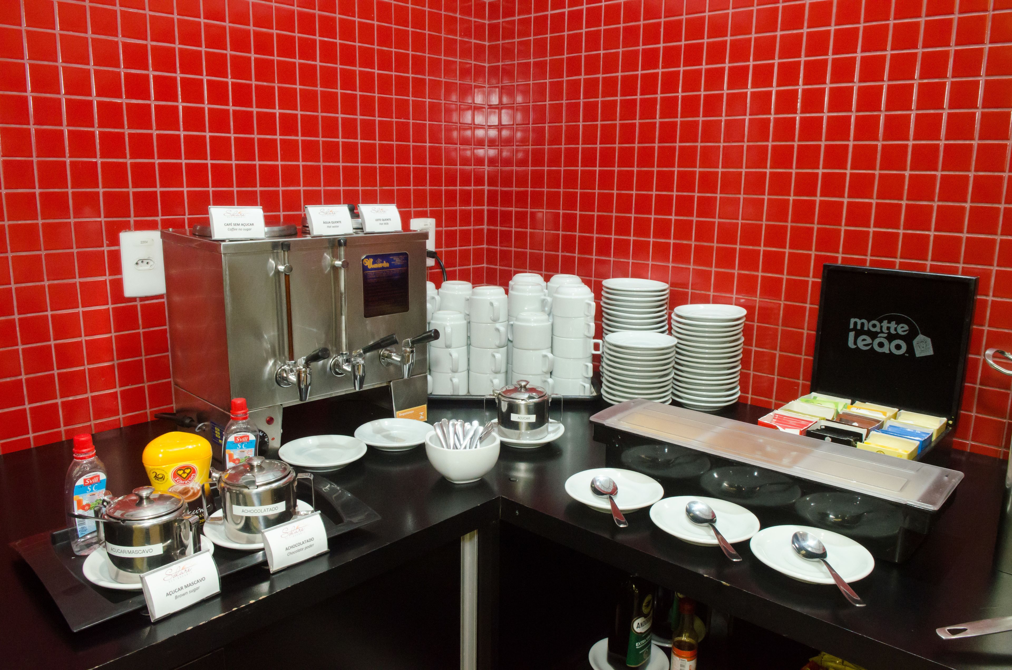 Un estación de desayuno autoservicio con cafeteras, té y diferentes condimentos.